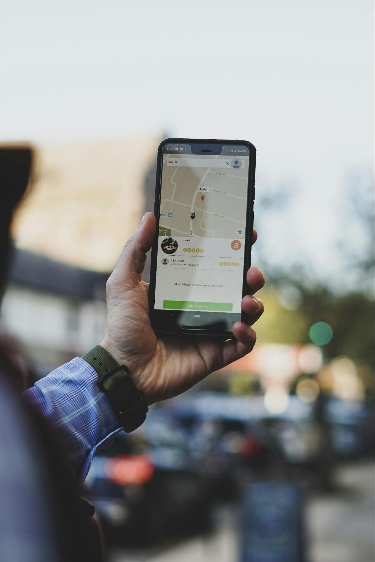 Hand holding a phone with a map app open outdoors