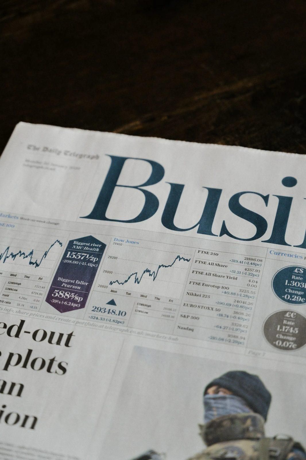 Newspaper open to its business section with stock market charts