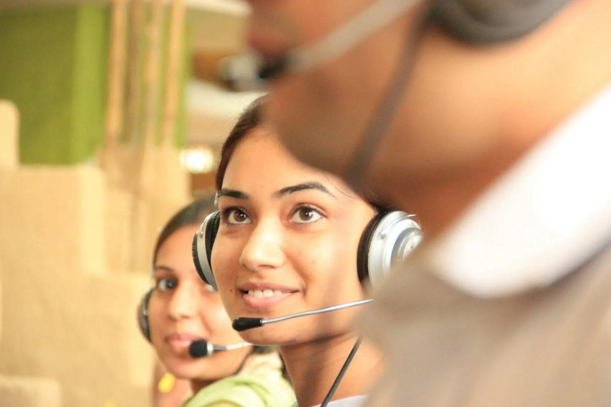 Smiling woman wearing a phone headset in a call center