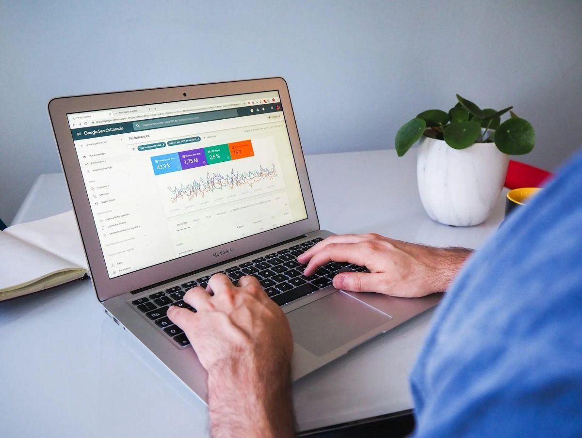 Laptop showing a Google Search Console performance report on a white desk
