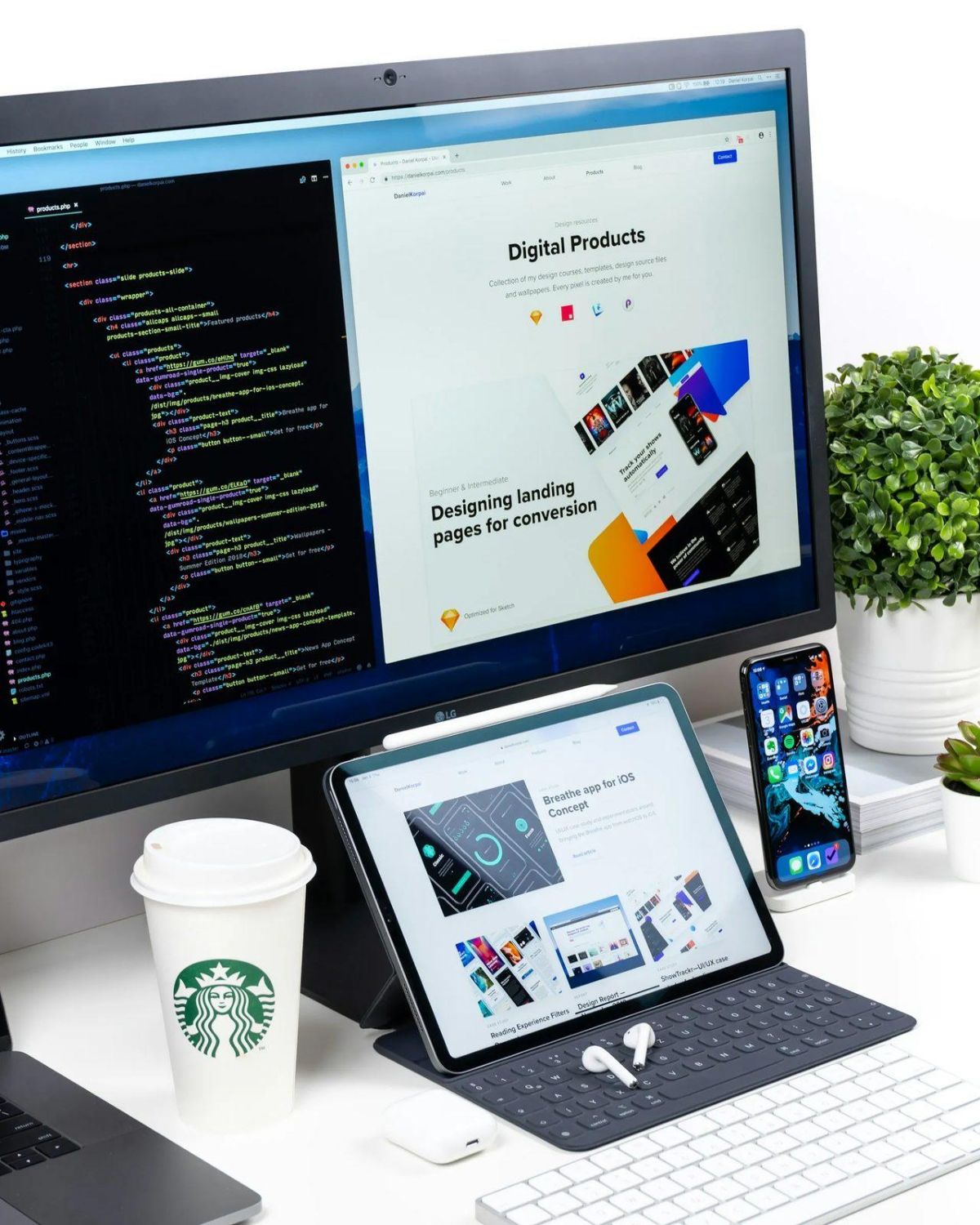Desk with a monitor, a tablet, a keyboard, a phone and a coffee cup