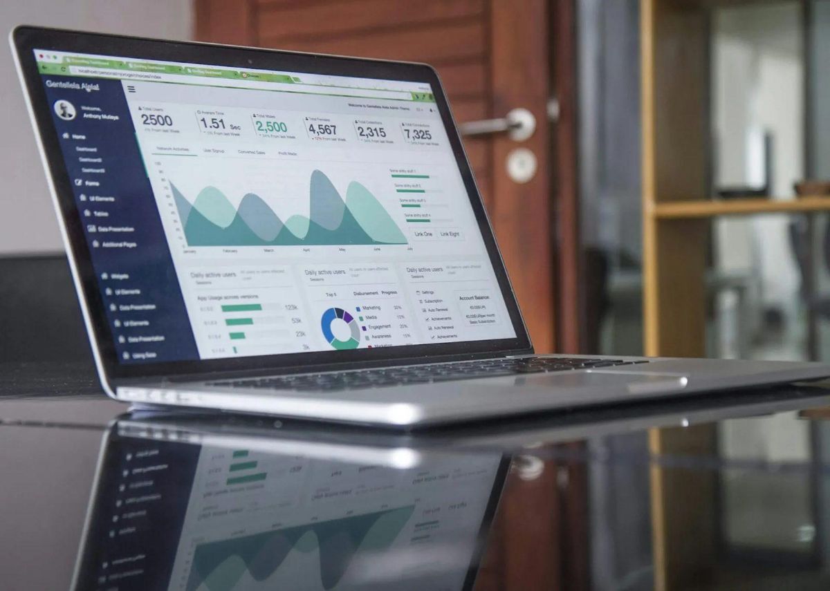 Laptop on a glossy desk showing a web analytics dashboard
