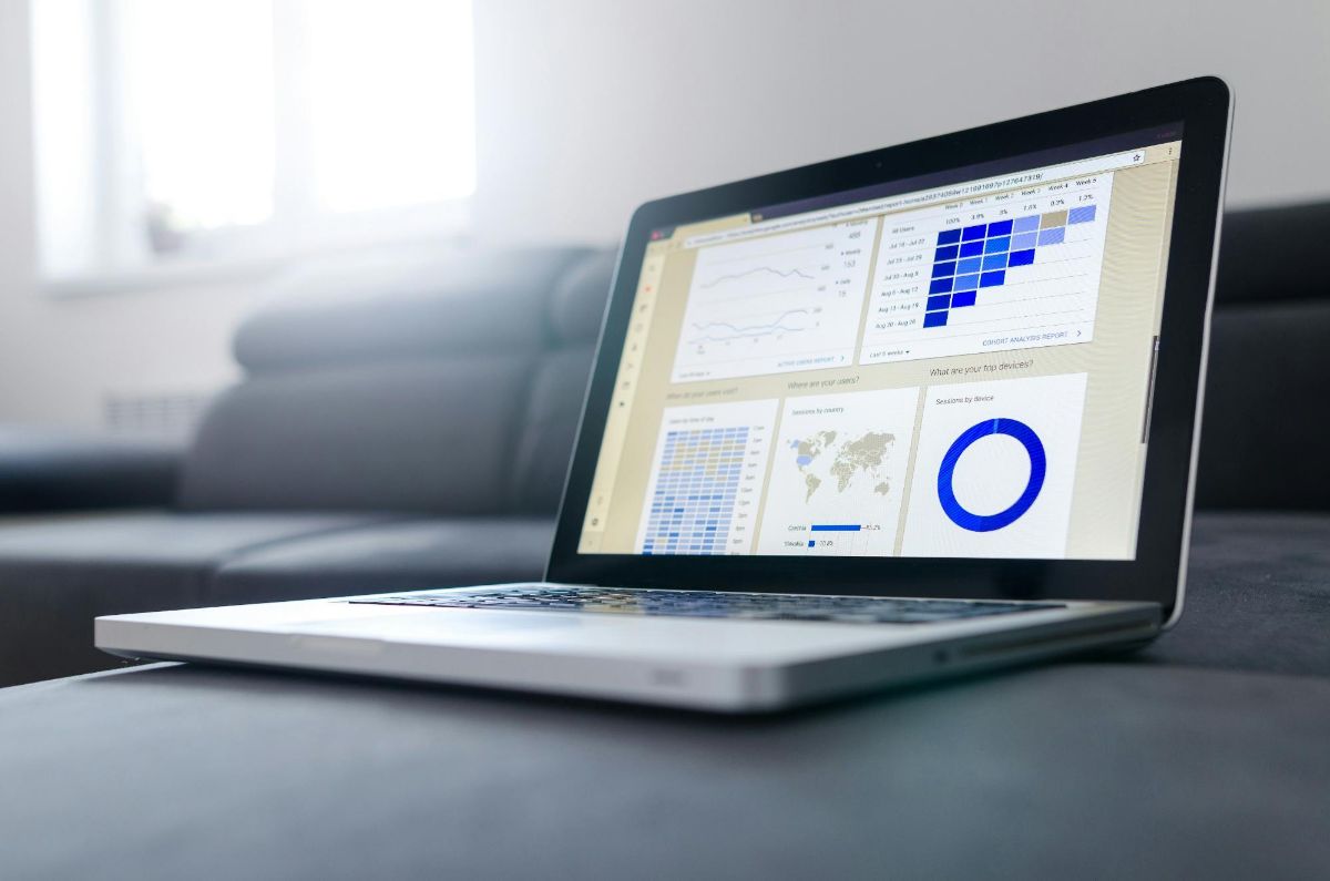 Laptop on a gray couch showing website analytics charts