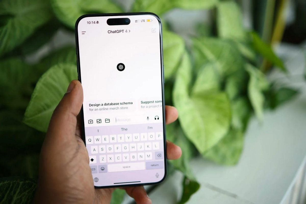 Hand holding a phone with the ChatGPT app open and the keyboard showing