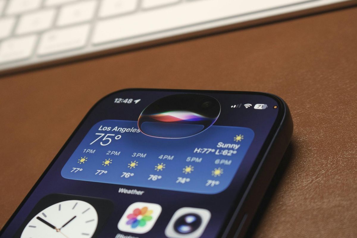 Phone screen showing a weather widget with Siri listening, beside a keyboard